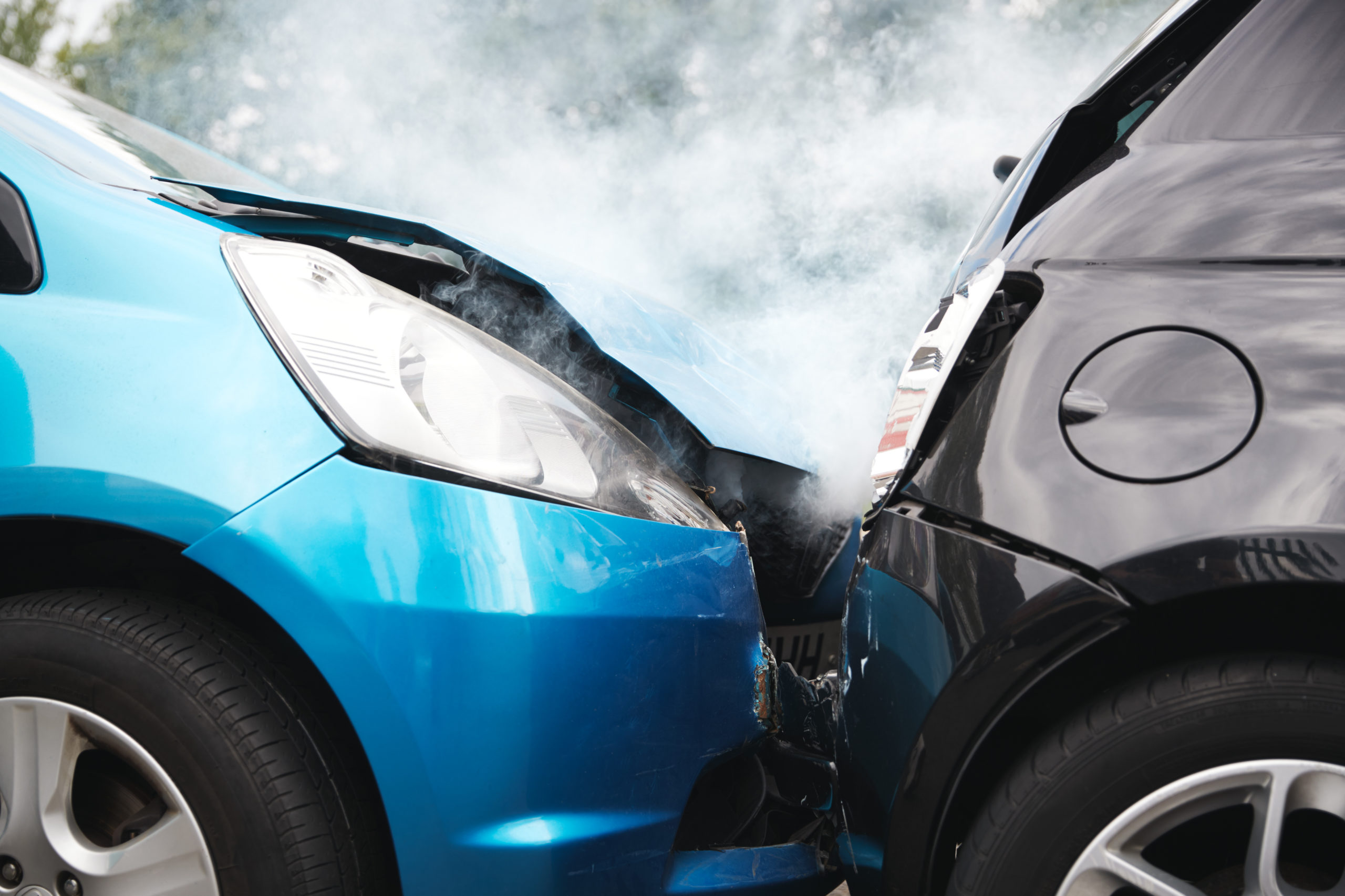 Damaged blue and black cars after a motor vehicle accident, illustrating teen car accident aftermath.