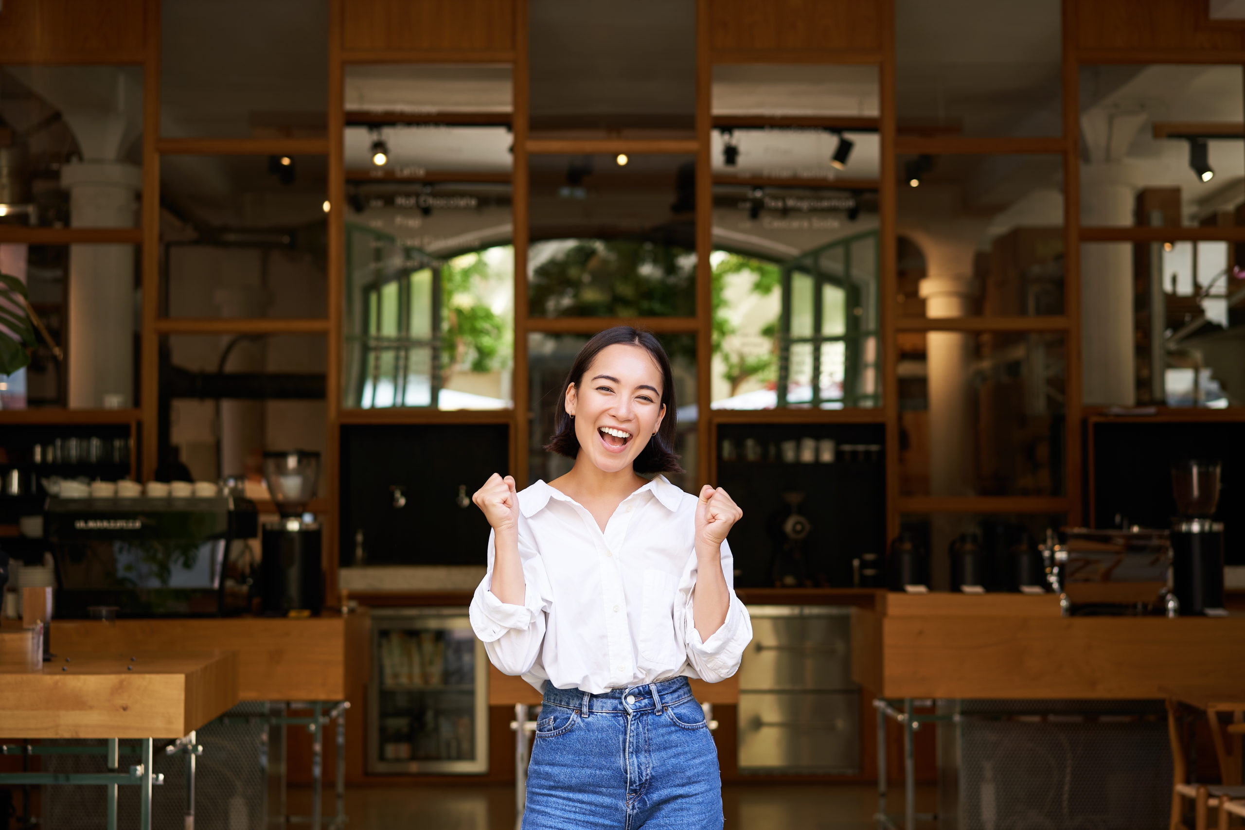 Enthusiastic Asian business owner celebrating restaurant success.