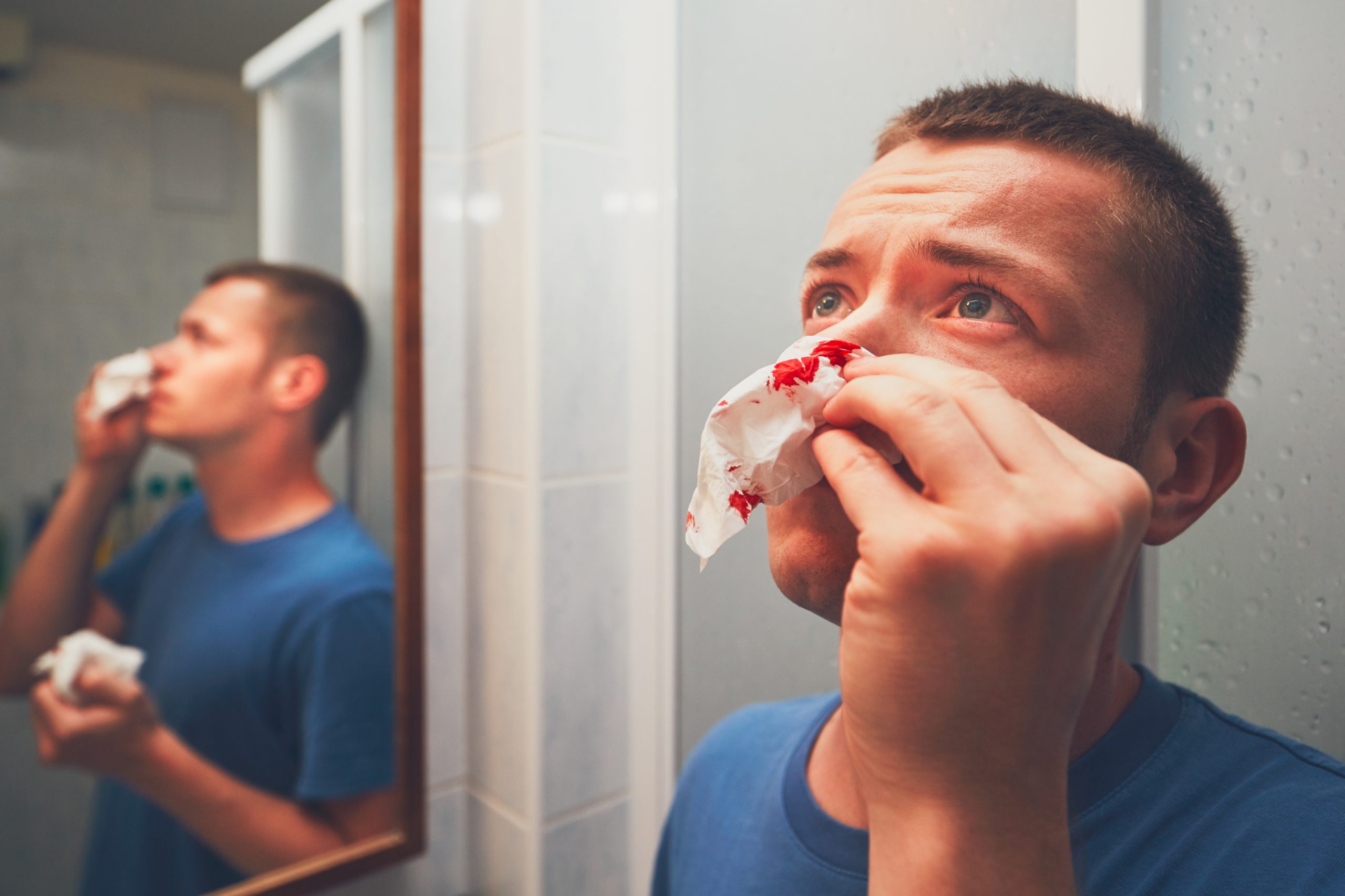Man with nosebleed in bathroom, illustrating common bathroom injuries