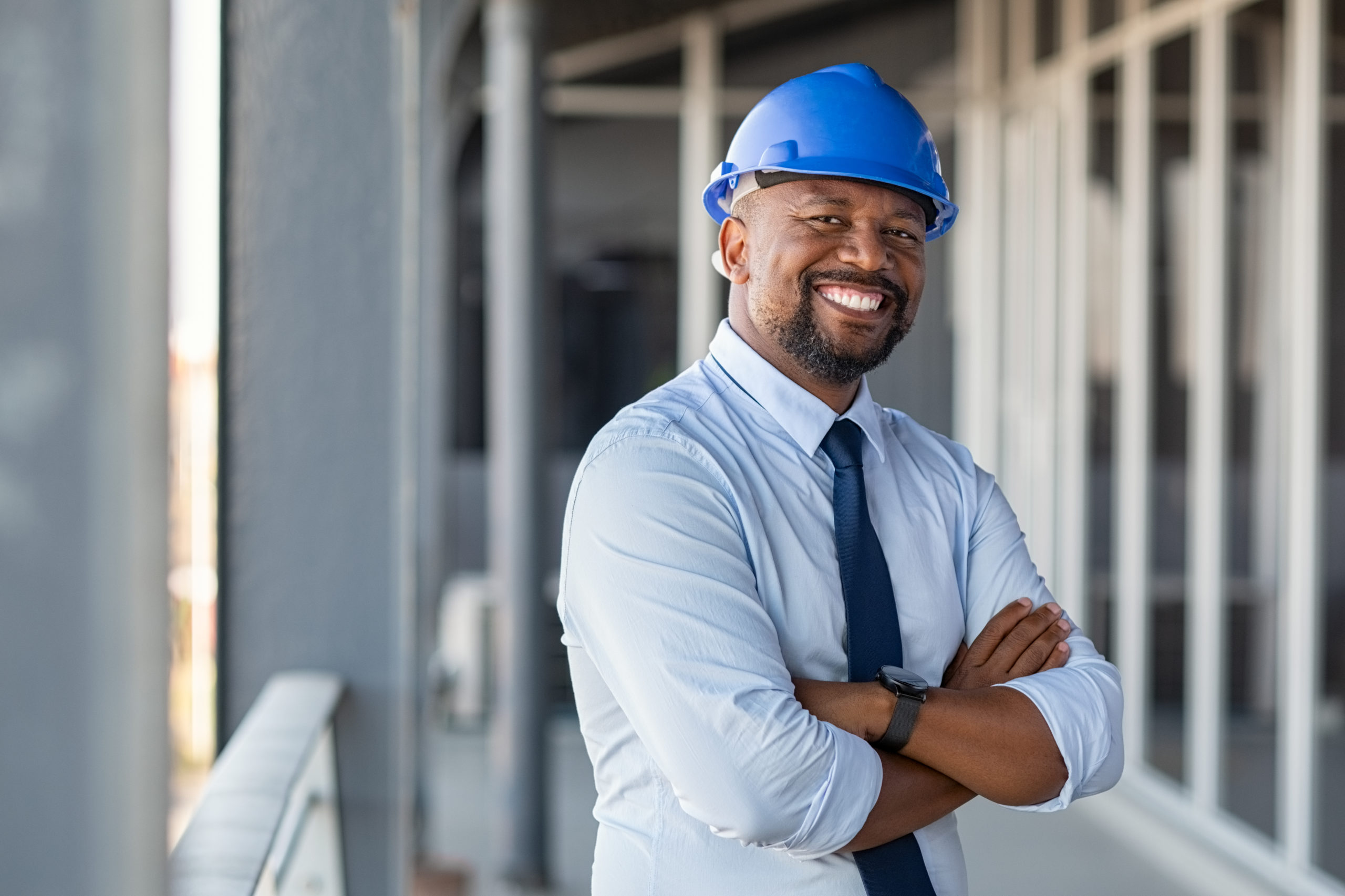 Contractor smiling at building site, opening own contracting firm