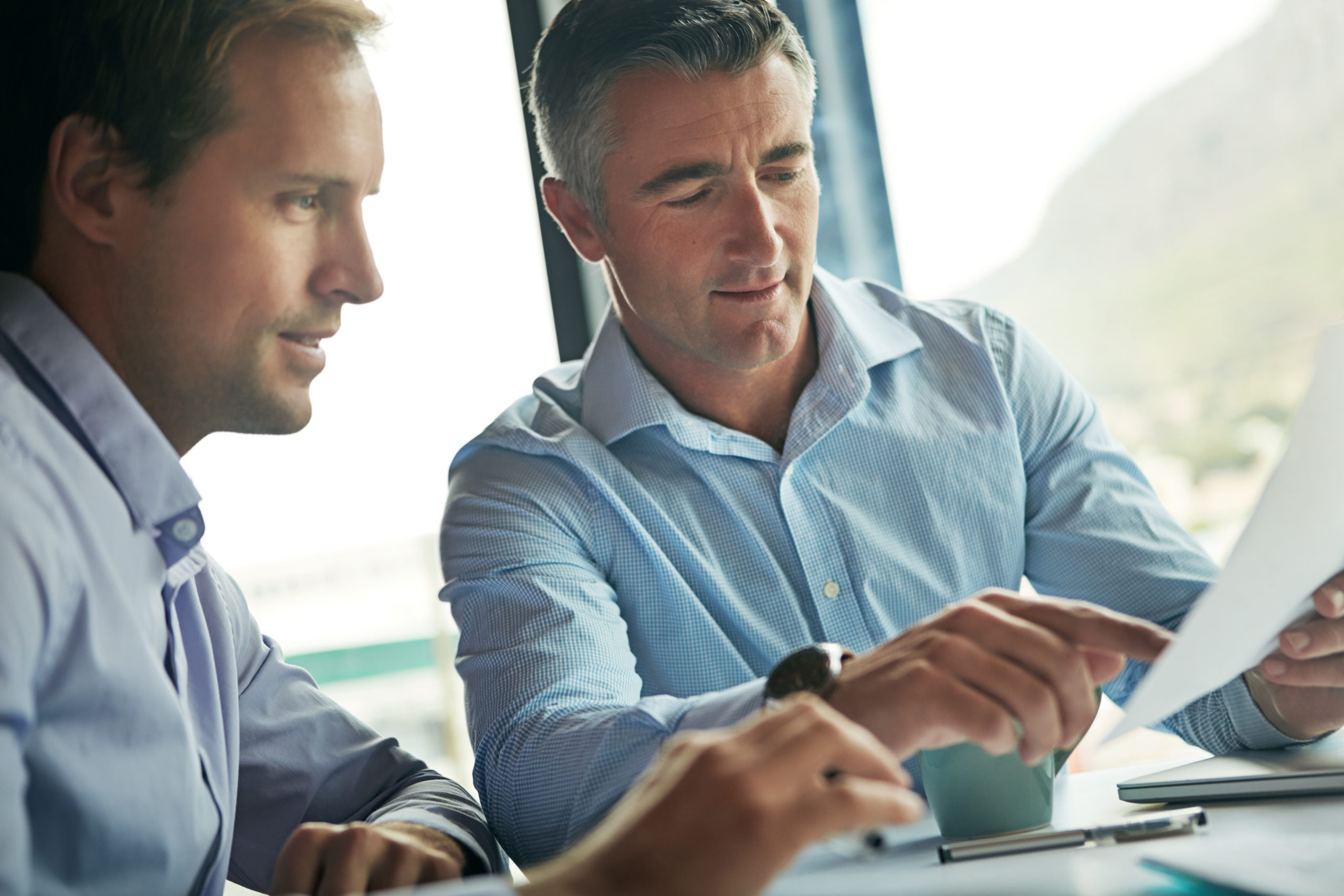 Two professionals discussing career coaching services and reviewing documents.