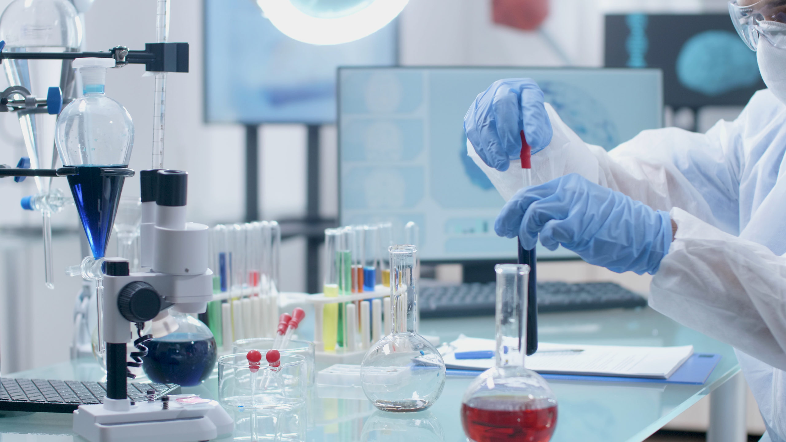 Scientist researcher working with medical test tubes and lab equipment, illustrating medical technology advancements.